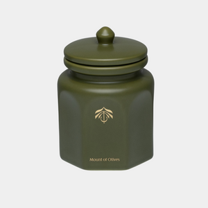 An olive green hexagonal ceramic candle vessel with a matching lid, featuring a gold logo and the text 'Mount of Olives' on the front, set against a light gray background.